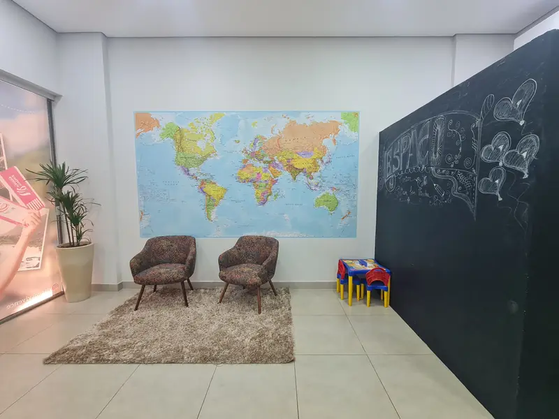 Espaço de espera com mapa-múndi e área kids