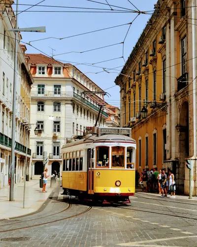 Bonde amarelo em rua histórica de Lisboa, Portugal